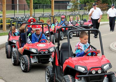 Children driving kid size cars