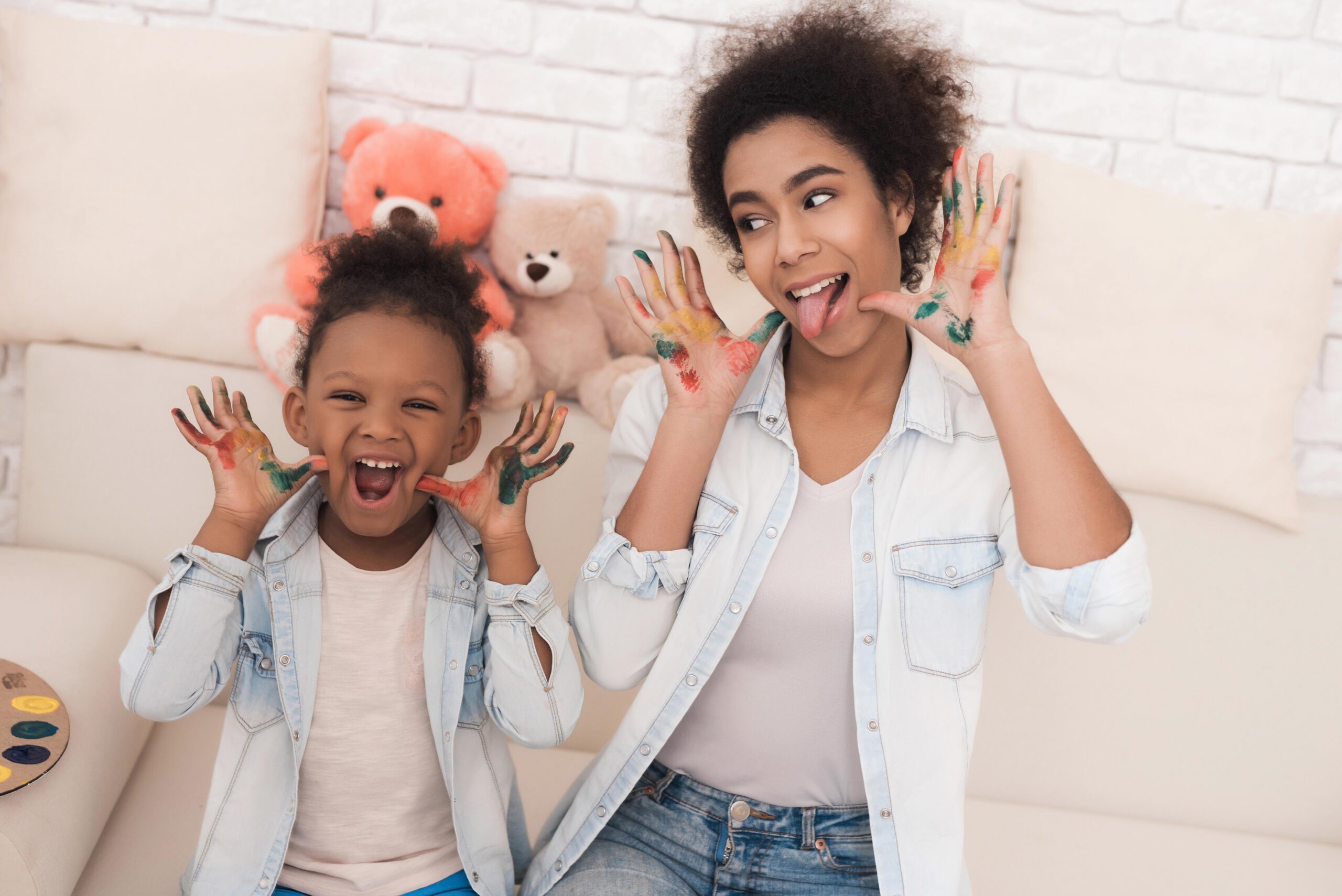 Babysitter and child playing with paint